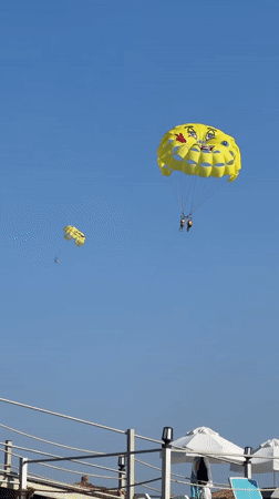 Sun, parasails, and rocky jumps on a packed Alanya beach