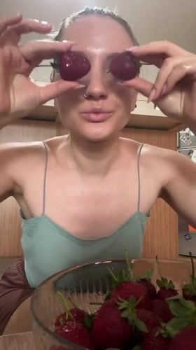 Woman plays with fresh strawberries in Turkish kitchen