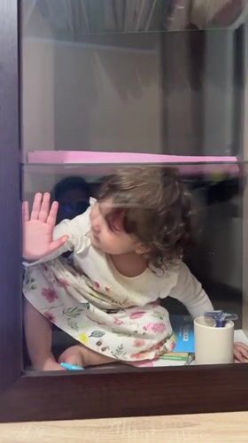 Child plays in glass display cases in Tobolsk