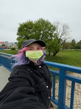 Masked individual films on Zagreb bridge amid spring blooms