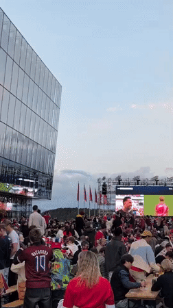 Outdoor fan zone crowd watches live sports on big screen in Stavanger