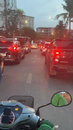 Scooter rider navigates heavy traffic in Pattaya City