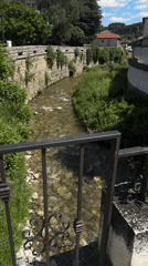 Town center exploration with river, fountain, and historic architecture
