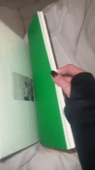 Person unboxes limited edition art book in UK bedroom
