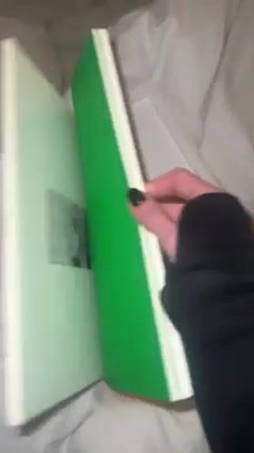 Person unboxes limited edition art book in UK bedroom