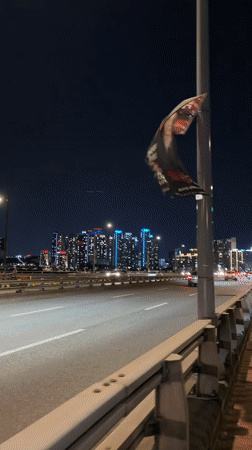 Damaged banner spotted on Seoul bridge during nighttime traffic