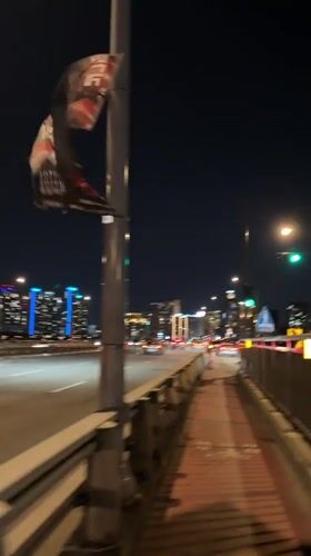 Damaged banner spotted on Seoul bridge during nighttime traffic