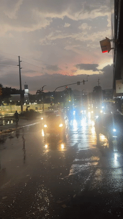 Post-rainfall evening traffic observed on wet Guayaquil streets
