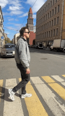 Pedestrian crosses street in sunny Saint Petersburg