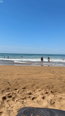 Sunny afternoon beach scene at Zarautz with boogie boarding