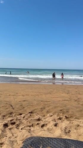 Sunny afternoon beach scene at Zarautz with boogie boarding