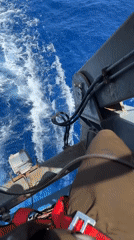 Ocean vessel transit documented with wake views, crew member