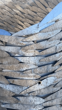 Wing sculpture and beachgoers captured in Jūrmala, Latvia