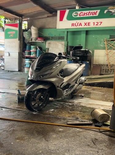 Early morning motorcycle wash service documented in Nha Trang
