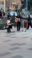 Live guitar performance on an outdoor plaza