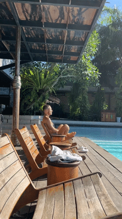 Man relaxes poolside in Petulu, Indonesia