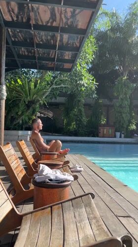 Man relaxes poolside in Petulu, Indonesia