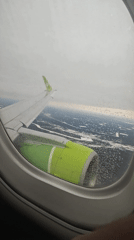 S7 Airlines passenger photographs wing view over snowy Russian forests