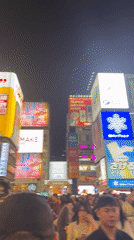 Tourists document typical scenes in Osaka's Dotonbori district