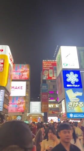 Tourists document typical scenes in Osaka's Dotonbori district