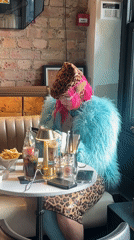 Pink-haired woman waves in London cafe, group gathers nearby