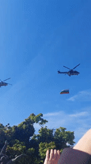Helicopters with Bulgarian flag fly over gathered crowds