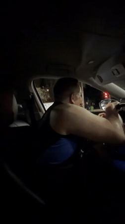 Couple enjoys music during nighttime drive through Malinovka intersection