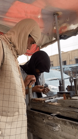 Metalwork underway at a street-side bench in Kandahar