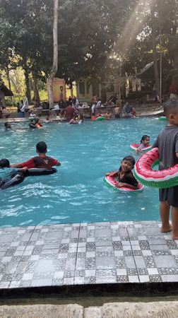 Crowded outdoor pool day in Mlowokarangtalun, Indonesia