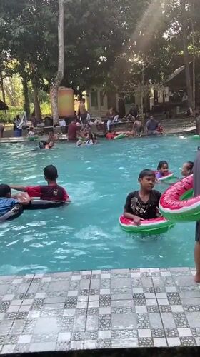 Crowded outdoor pool day in Mlowokarangtalun, Indonesia