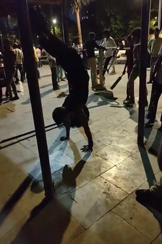 Person performs evening calisthenics workout at Mumbai public park