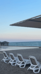 Kemer beach resort at dusk, chairs empty, mountains behind