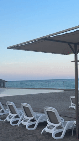 Kemer beach resort at dusk, chairs empty, mountains behind