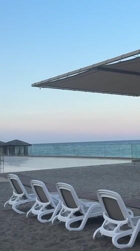 Kemer beach resort at dusk, chairs empty, mountains behind