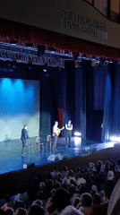 Suited ensemble performs live on a theater stage