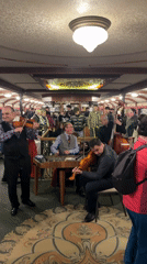 Live Folk Music Performance Draws Dancing Patrons in Ornate Restaurant