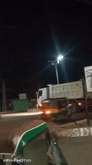 Nighttime street hustle: tuk-tuks, overloaded cars, and roadside grilling