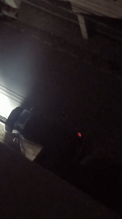 Nighttime activity on dark Dhaka streets, flashlights and headlights