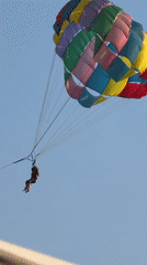 Beach lounging and parasailing on a busy summer day