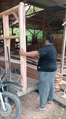 Workers Move Large Wooden Frame in Woodworking Shop