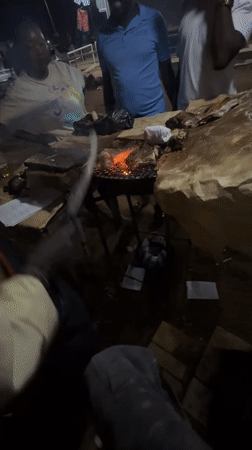 Nighttime street barbecue gathering documented in Bukuru, Nigeria