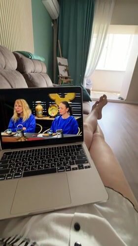 Woman watches laptop shows on couch in Birobidzhan