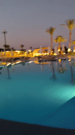 Resort pool at dusk, lights on, sky still colorful