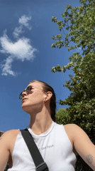 Person in tank top observed looking around outdoors
