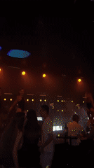 Crowded nightclub in Plovdiv, stage lights, dancing crowd