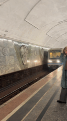 Moscow Metro train arrives at station with Russian flag visible