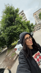 Woman Takes Selfie on Tree-Lined Street in Pleven
