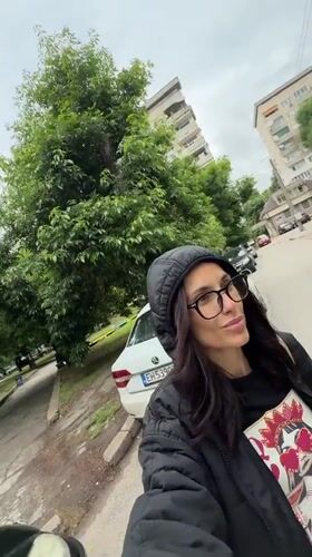 Woman Takes Selfie on Tree-Lined Street in Pleven