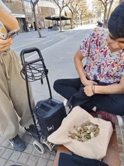 Street performer handles coins in Barcelona pedestrian area