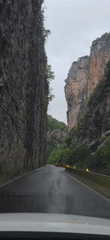Vehicle travels through wet canyon road near Castejón de Sos